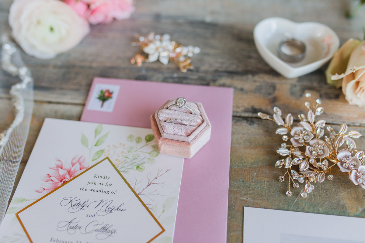 Pink wedding details invitations earrings flat lay 