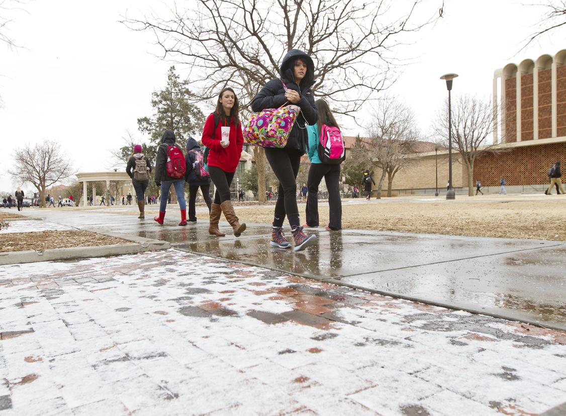 Students walk across campus on wet and icy sidewalks on Texas Tech's campus on Feb. 11, 2014.