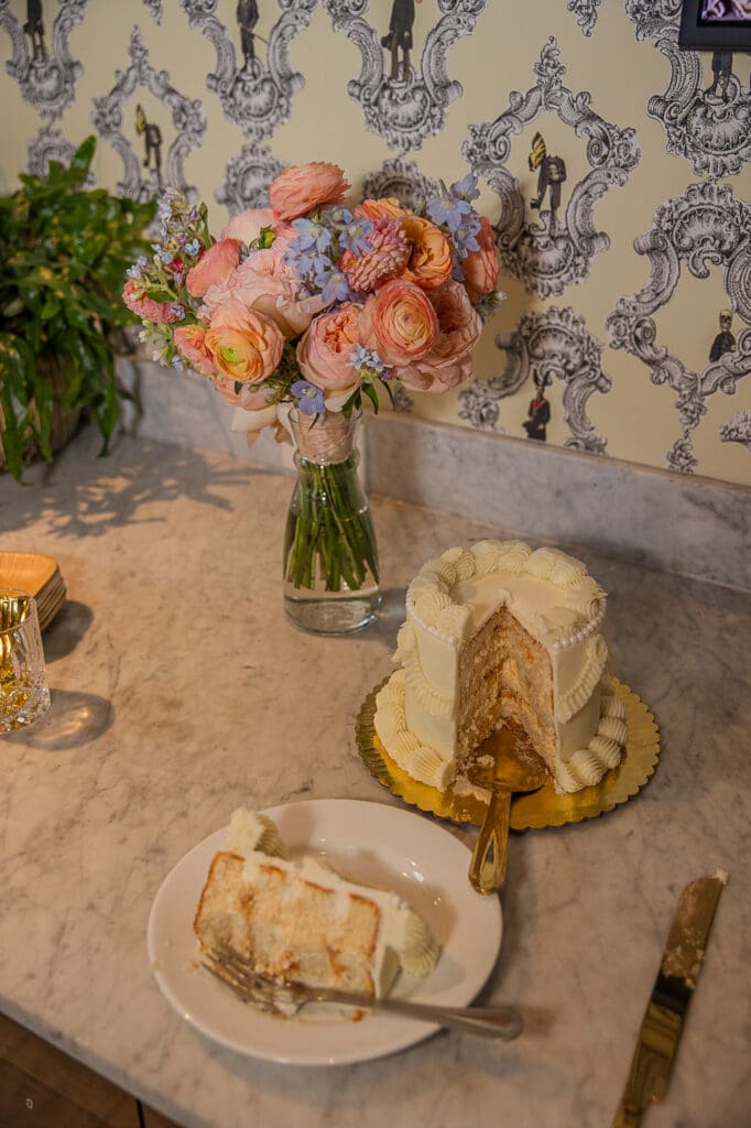 cut wedding cake with floral bouquet